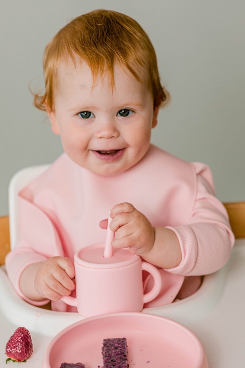 Baby girl smiling using Starting Solids Australia core silicone feed products for starting solids.