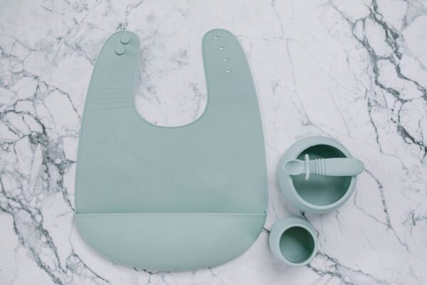 Blue (Meringue) silicone bib, cup, bowl and spoon set for babies on a marble bench by Starting Solids Australia