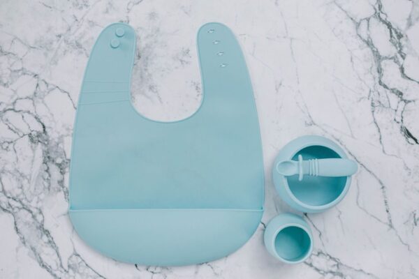 Blue Lemonade silicone bib, cup, bowl and spoon set for babies on a marble bench by Starting Solids Australia