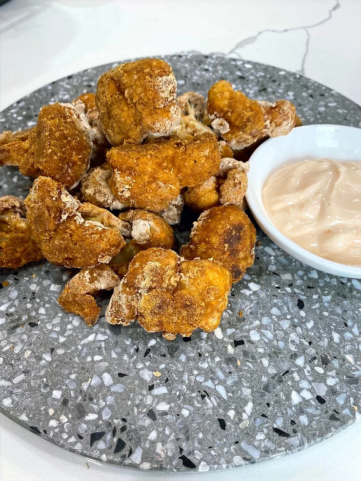 Southern Spiced Cauliflower on terrazzo plate with dipping sauce - Starting Solids Australia Recipe.