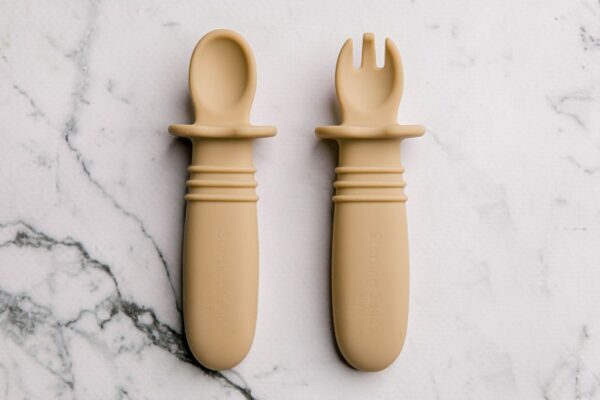 Yellow silicone baby cutlery on a marble bench by Starting Solids Australia