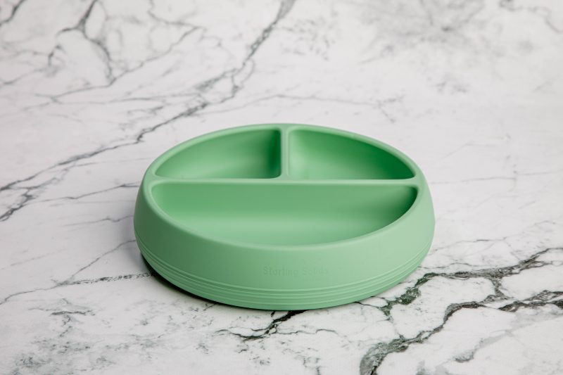 Suckie Scoop Divided Plate in 'Mint Crisp' green by Starting Solids Australia on a marble bench.