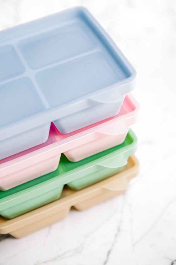 Stack of coloured Freezie Trays by Starting Solids Australia on a marble bench.