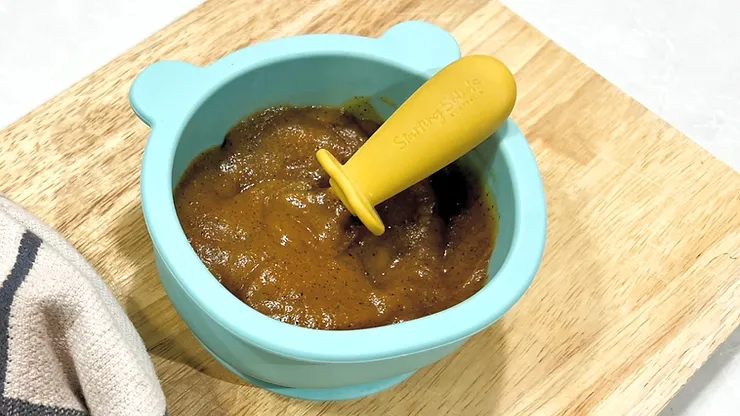 Sweet Chicken and lentils purée in blue bear suction plate with yellow silicone baby cutlery on a wooden board - Starting Solids Australia recipe.