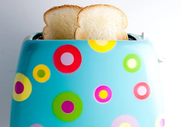 White toast popping out of a colourful toaster.