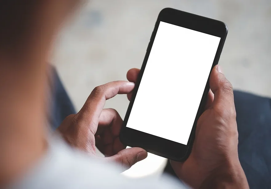 Hands holding smartphone with blank white screen