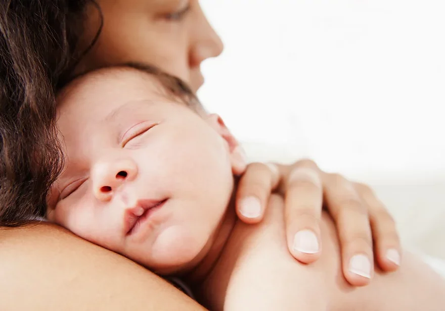 Baby sleeping on mother's shoulder