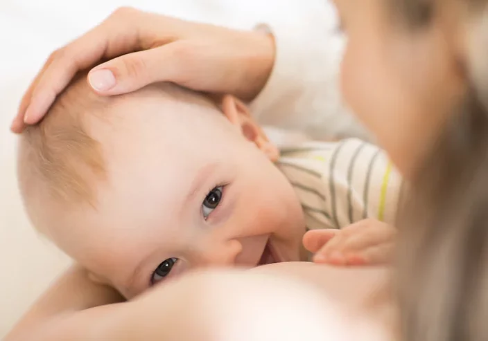 baby smiling whilst breastfeeding