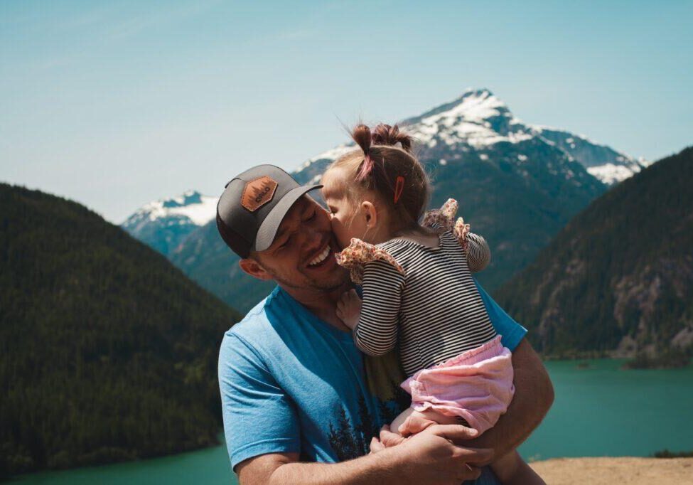 man carrying her daughter smiling