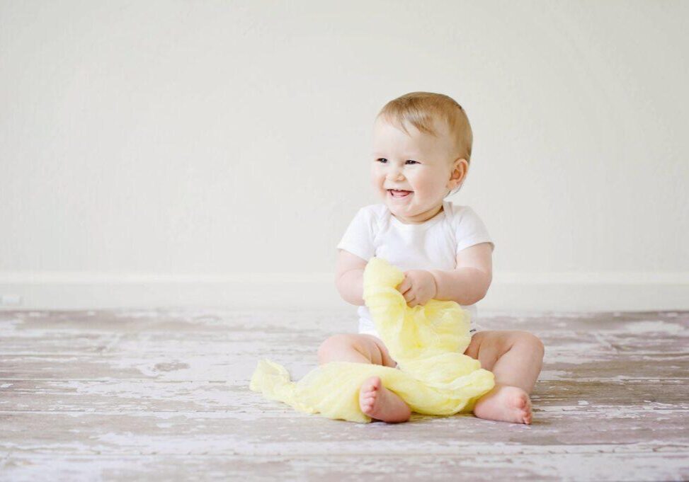 toddler sitting while smiling