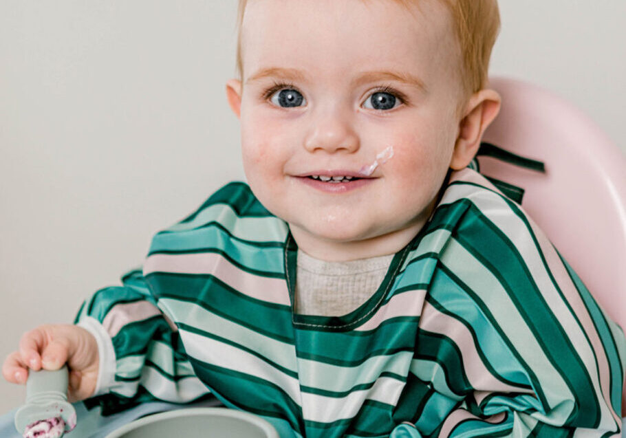 Baby eating puree with Starting Solids Australia feeding ware in a high chair.